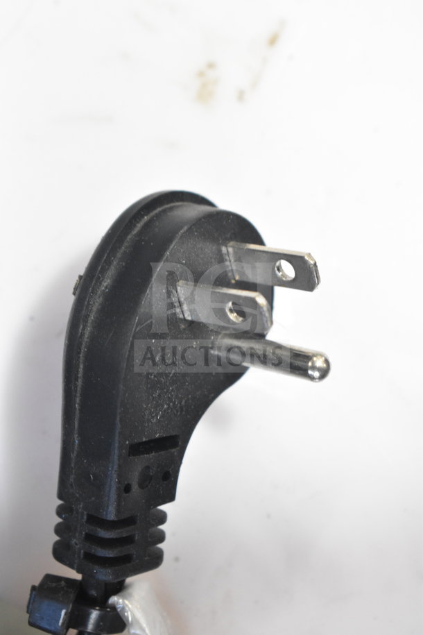 Power plug for JBL Partybox 300 speaker display, black, 3-prong, showing cord attachment point, moderate wear.