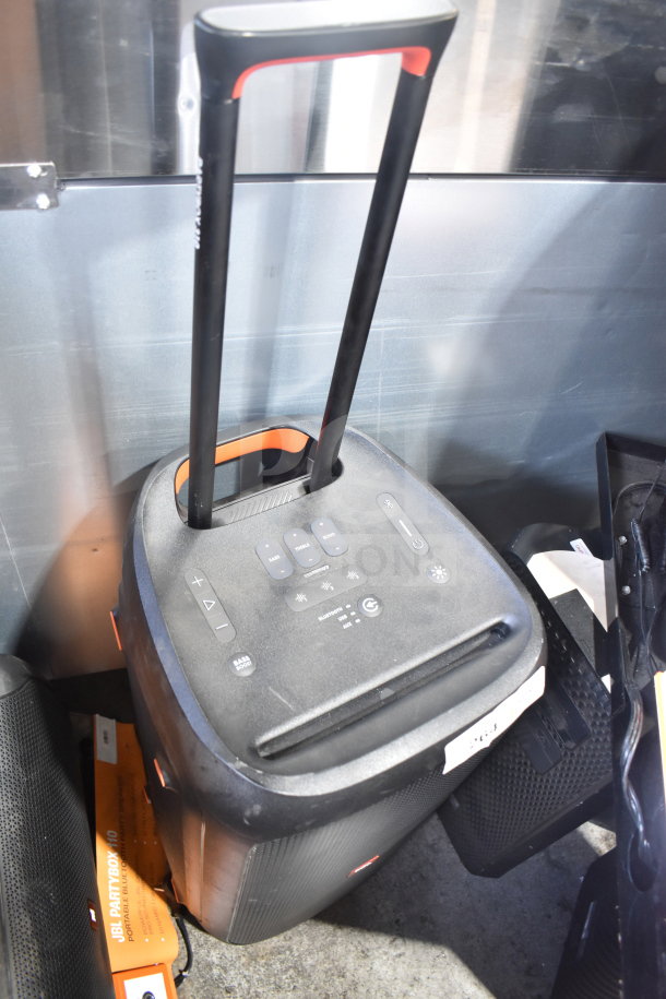 JBL Partybox 310 Speaker with handle, control buttons visible, used condition. Appears portable, black and orange design.