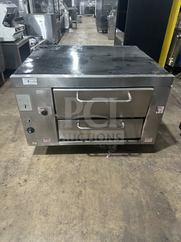 Attias commercial stainless steel gas-powered double deck pizza oven, countertop model, with dual controls and visible labels.