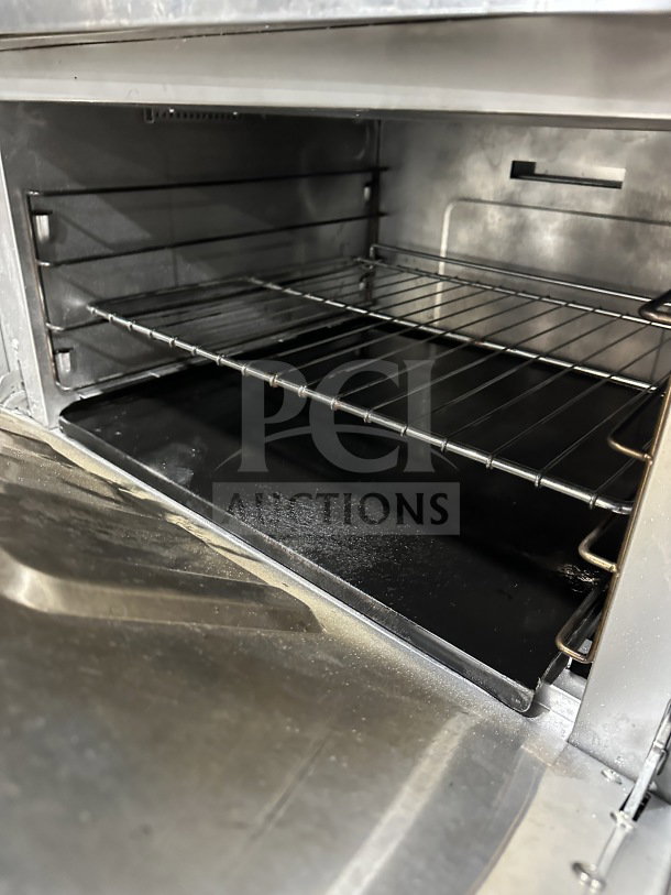 Qualite QLG36NG stainless steel range/oven interior with wired rack, in good condition, showcasing spacious cooking area.