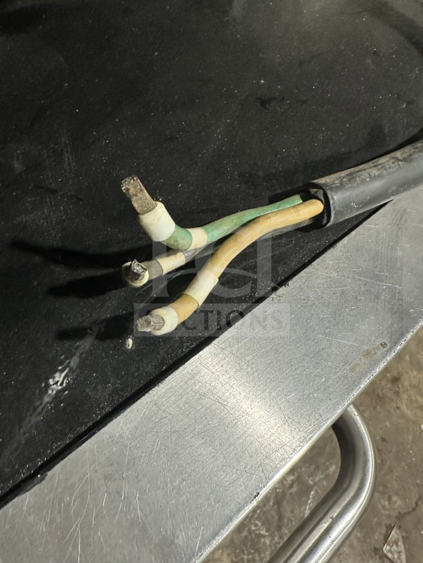 Loose wires on a metal surface, possibly indicating the electrical components of the Thermoplan Mastrena II espresso machine.