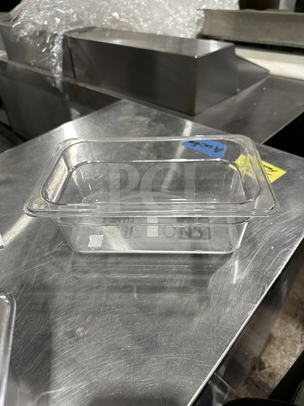 Winco SP7404 clear polycarbonate food pan, 1/4-size, 4" deep, brand new condition, resting on stainless steel surface.