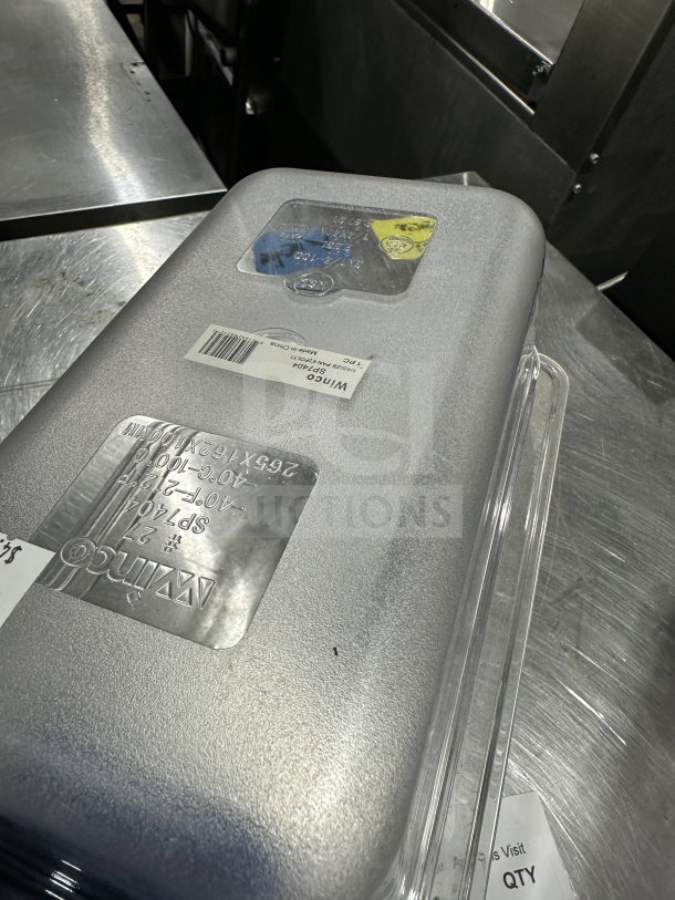 Brand new Winco SP7404 clear polycarbonate 1/4-size food pan, 4" deep. Labels indicate model and specifications.