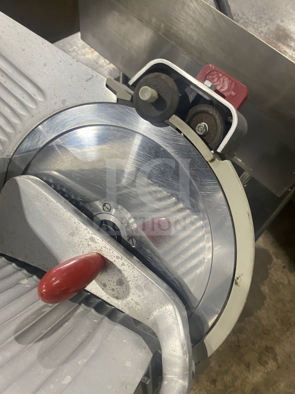 Berkel Model 827-A stainless steel meat slicer, electric-powered, with red handle and blade guard, on legs.