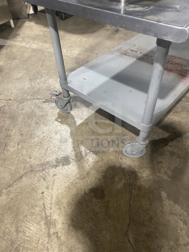 Commercial stainless steel equipment stand with two compartments, on casters. Well-maintained condition, ideal for kitchens.