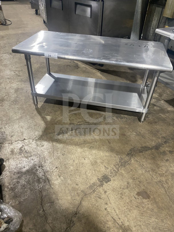 L&J stainless steel equipment stand with two compartments on legs, commercial grade, metal surface shows light wear.