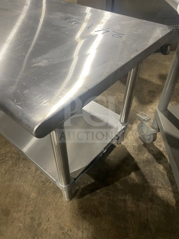 L&J commercial stainless steel two-compartment equipment stand on legs, shows minor surface scratches, sturdy design.