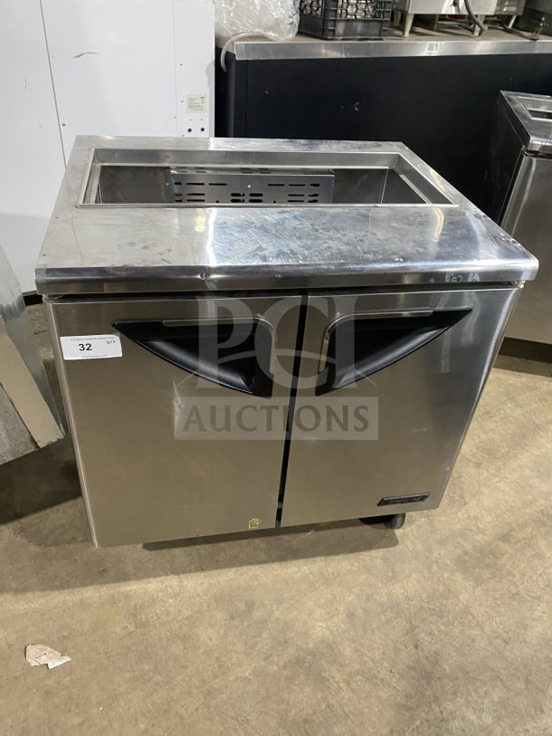 Turbo Air TST-36SD stainless steel refrigerated sandwich prep table with cutting board, 2-door storage, on casters.
