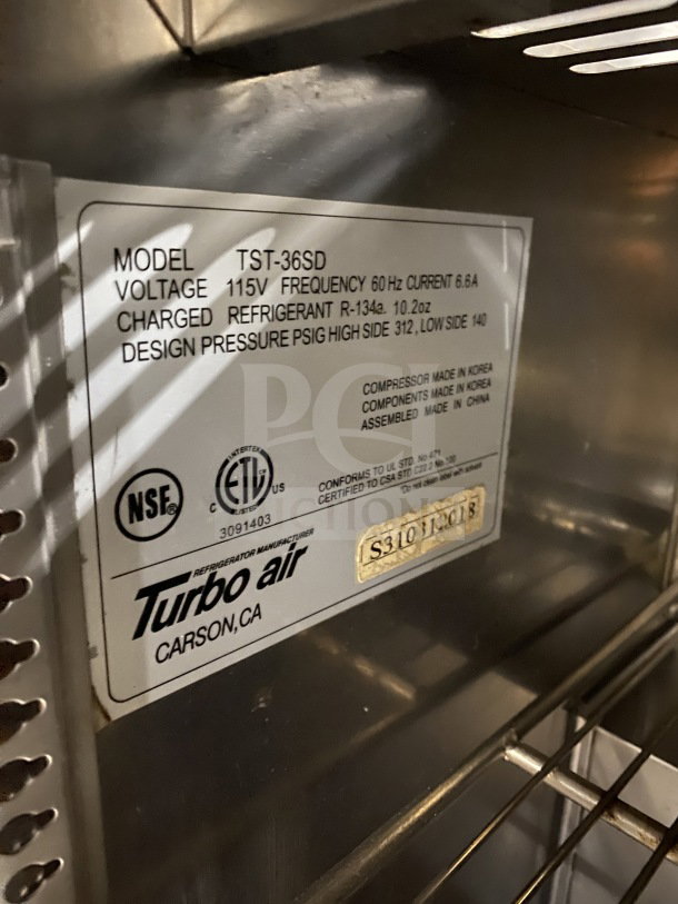 Turbo Air TST-36SD refrigerated sandwich prep table, stainless steel, 2-door storage, includes commercial cutting board, on casters.