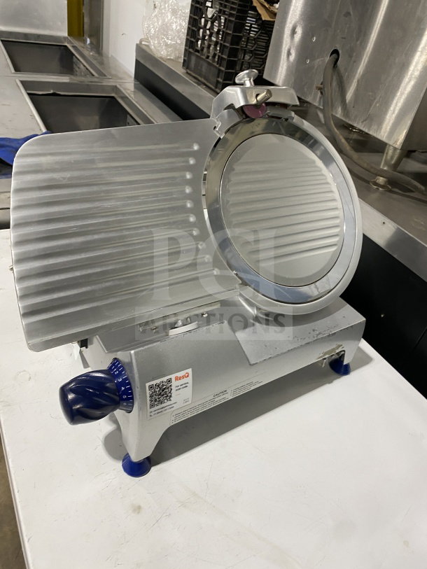 Commercial stainless-steel countertop meat slicer with adjustable knob and visible ResQ label. Electric-powered on stable legs.