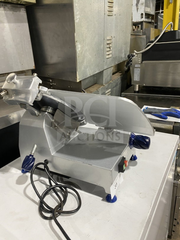 Commercial stainless-steel electric countertop meat slicer on legs, power cord visible, excellent condition.