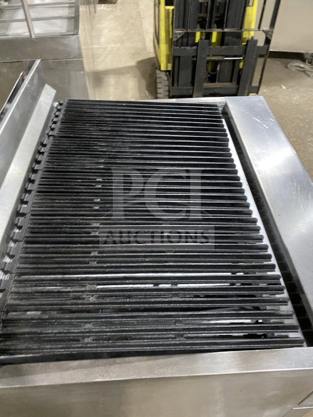 American Range commercial stainless steel gas range with full charbroiler, standard oven base, wired rack, and casters.