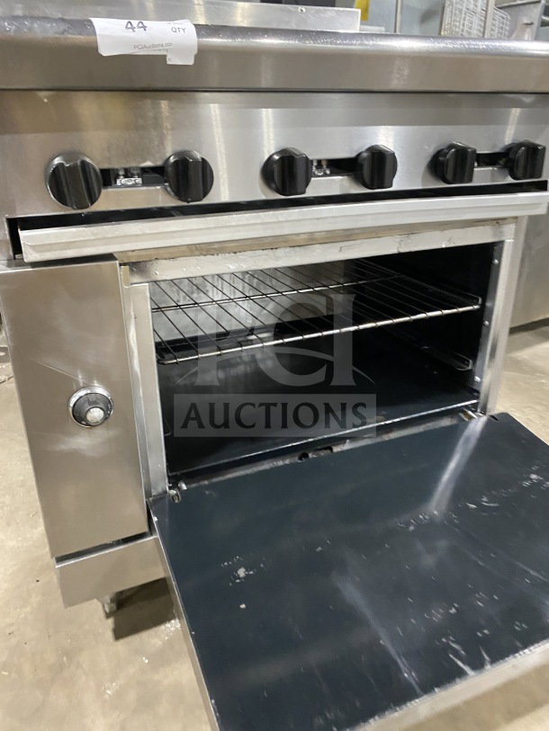 American Range commercial stainless steel gas-powered range with full charbroiler and standard oven base, wired rack, on casters.