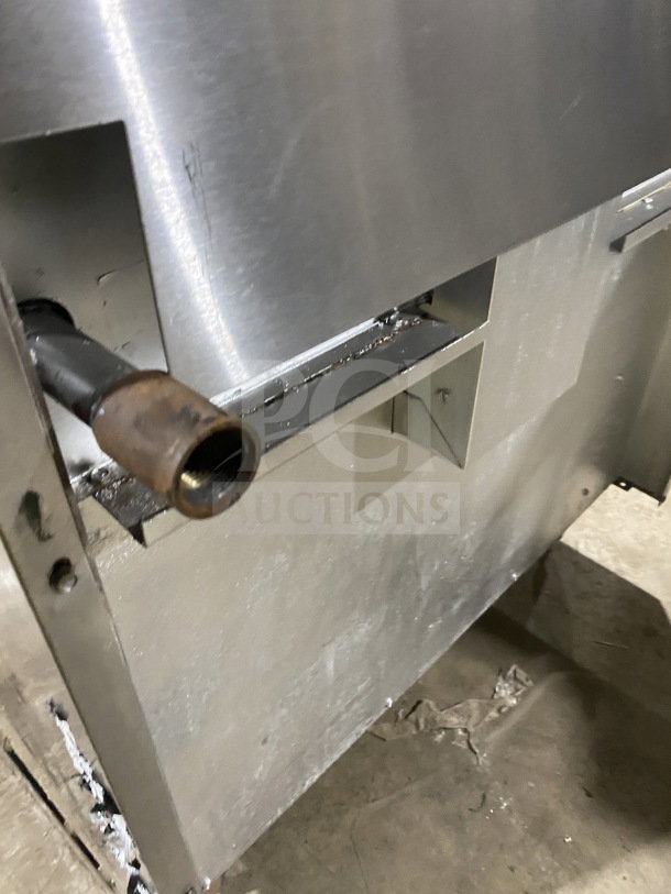 American Range commercial stainless steel gas range, featuring a full charbroiler, standard oven base, and wired oven rack on casters.