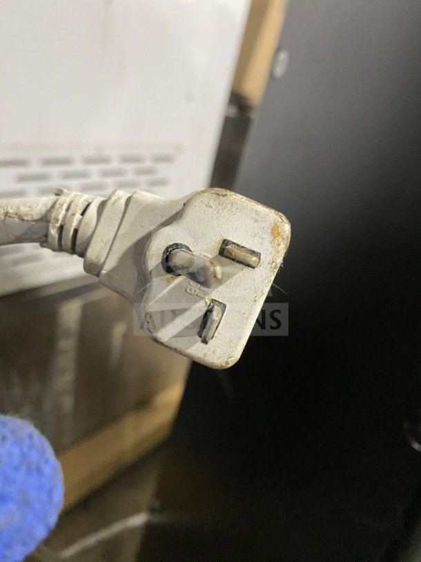 Close-up of a plug for Turbo Air TOM-40M(B) refrigerated display case, showing wear. Model and serial number not visible.