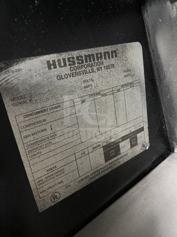 Hussmann commercial merchandiser label detailing electrical specs, 115V, and serial info, Gloversville, NY.