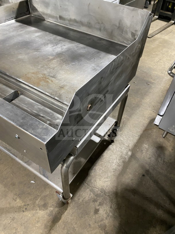 AccuTemp Accu-Steam stainless-steel flat-top griddle on rolling stand, gas-powered, sturdy design, good condition.