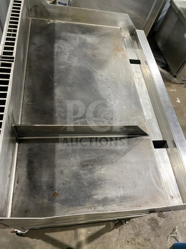 AccuTemp Accu-Steam commercial stainless-steel flat-top griddle on rolling stand. Gas powered. Visible wear and discoloration.