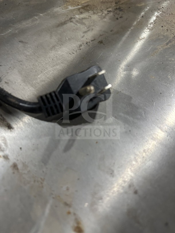 Power plug of Arctic Air ARCB60CZ refrigerated chef base, showing stainless steel surface with minor scuffs.