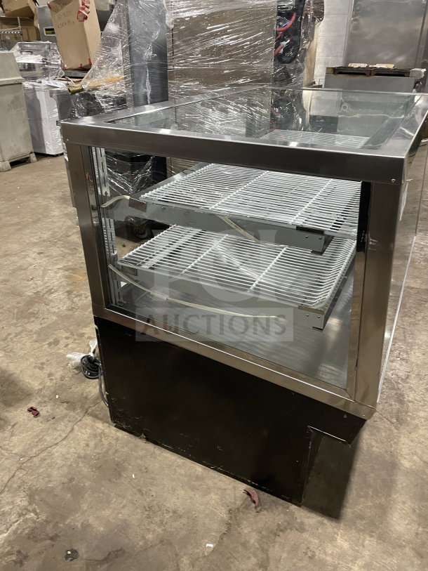 Commercial square glass refrigerated display case with poly-coated wired racks, electrical powered. Suitable for bakery or deli.