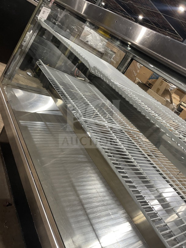 Commercial square glass refrigerated bakery/deli display case with poly coated wired rack and electrical powering, in good condition.