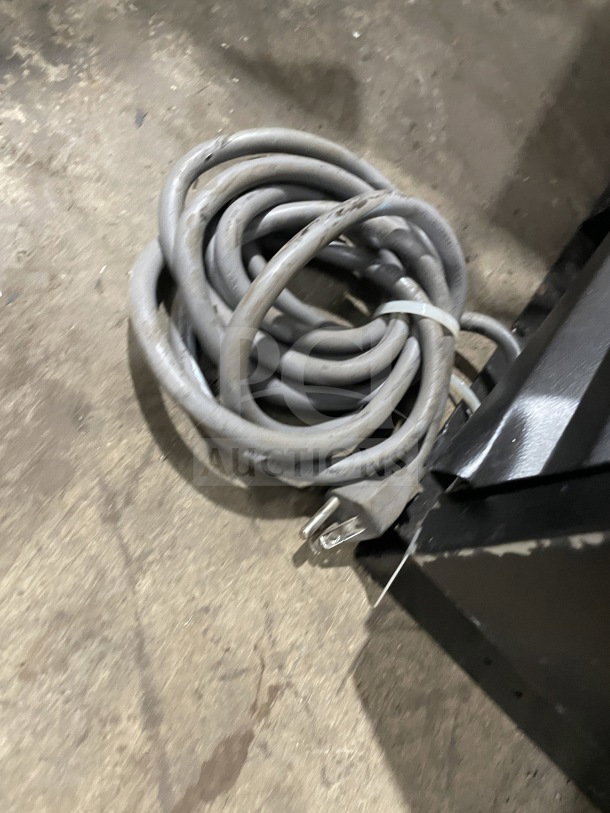Coiled power cord for Turbo Air TBB-2SB bar back cooler, visible near black and stainless steel unit corner.