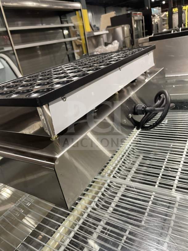 Commercial electric 50-hole mini pancake maker, stainless steel body, excellent condition, with a power cord attached.