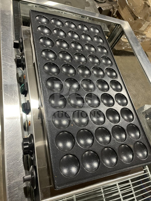 Commercial electric mini pancake maker with 50-hole plate, clean and functional, featuring durable knobs for temperature control.