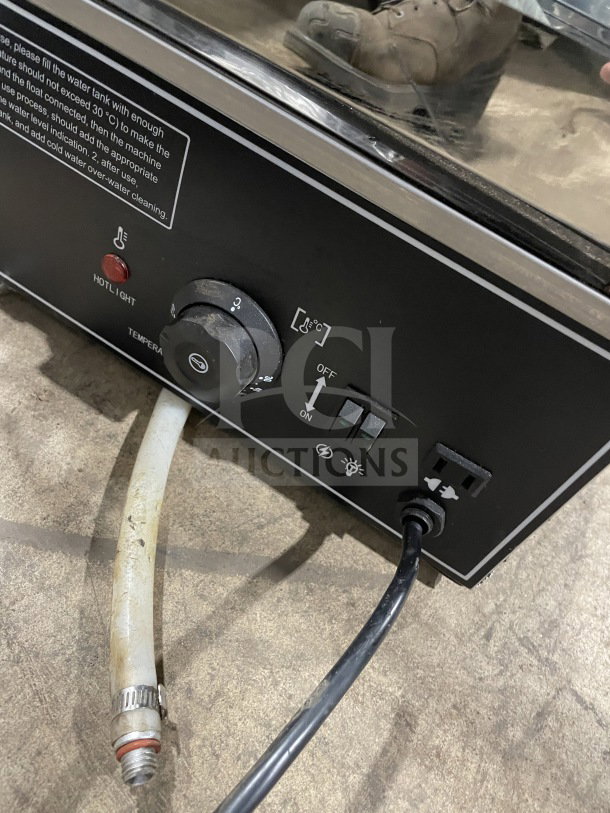 Commercial food steamer model ESTC-16, with glass and chrome wire rack. Visible dials and hoses, powered electrically.