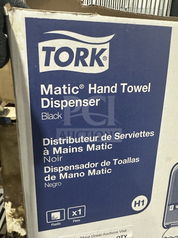 Tork Matic Series 302030 black hand towel dispenser, new in box, commercial-grade, labeled in multiple languages.