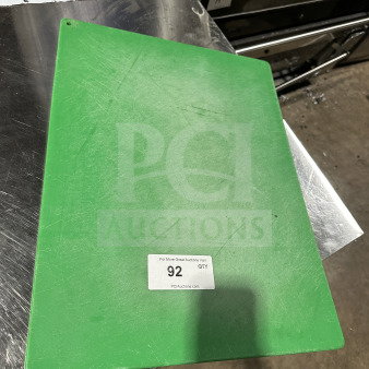 Used green commercial plastic cutting board with visible scratches. Item label indicates auction lot 92.
