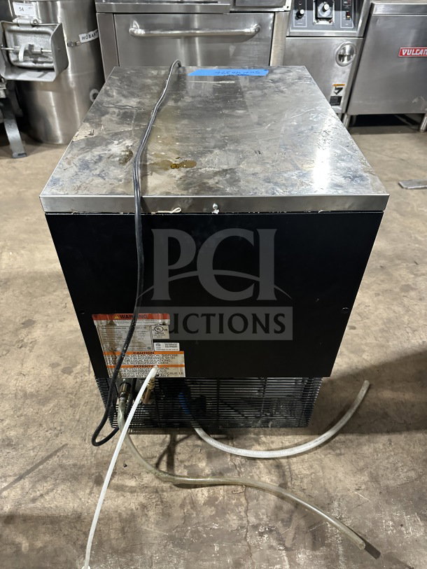 Manitowoc undercounter stainless steel nugget ice machine, Model UNP0200A161, with visible cables and caution labels.