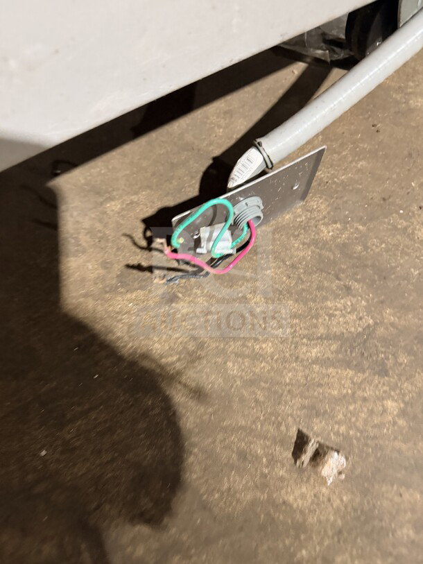 Loose electrical wiring near the base of the Hoshizaki F-1001MAH ice machine, model and serial tag visible.