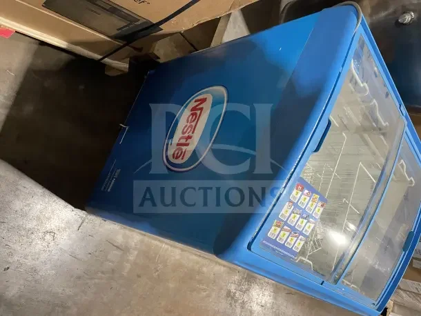 AHT RIO S100 commercial ice cream display freezer in blue with Nestlé branding. Features glass lid, on casters, 115V, 1 phase.