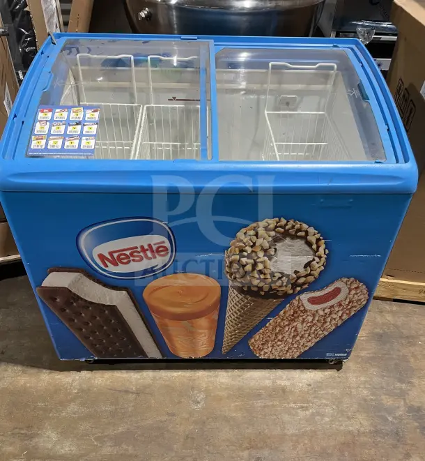 AHT Commercial Ice Cream Display Freezer, Model RIO S100, 115V 1 Phase, on casters, with Nestle branding, in working condition.