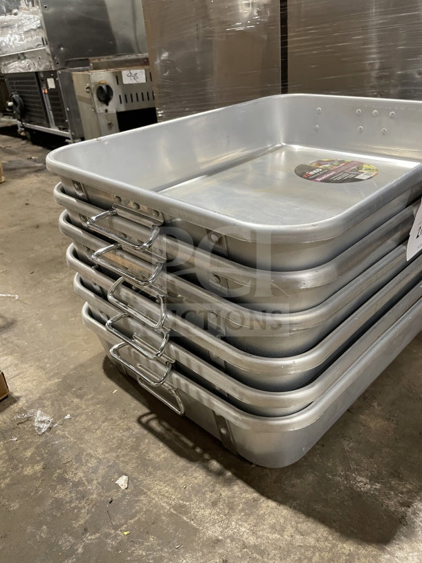 BRAND NEW Winco ALRP-1824 commercial heavy-duty double roaster with straps and handles, stack of trays in warehouse.