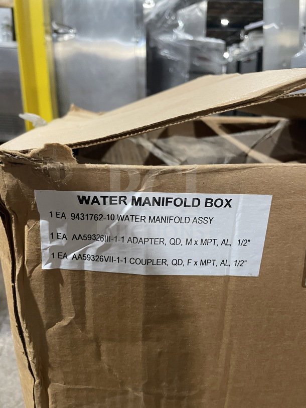Cardboard box labeled "WATER MANIFOLD BOX" with item details for a military outdoor water manifold distribution block.