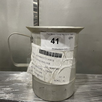 Brand new stainless steel liquid measuring cup, commercial surplus, with handle and visible auction and item tags.