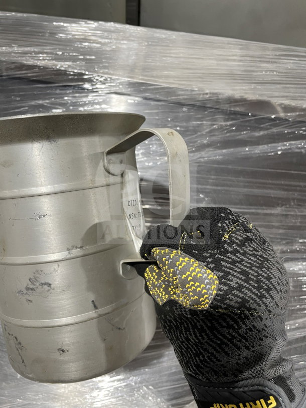 Brand new stainless steel liquid measuring cup, commercial surplus. Features a sturdy handle and visible markings.