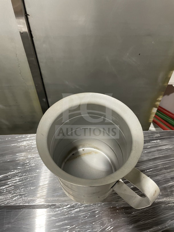 Brand new commercial stainless steel liquid measuring cup with a sturdy handle. Ideal for precise measurements.