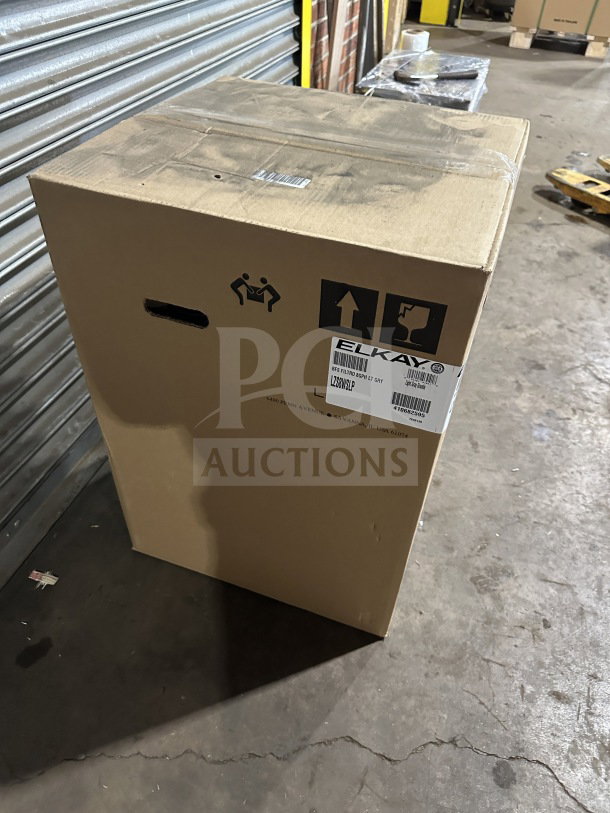 Cardboard box containing a brand new Elkay LZS8WSLP hydration station. Box shows labels with model and handling symbols.