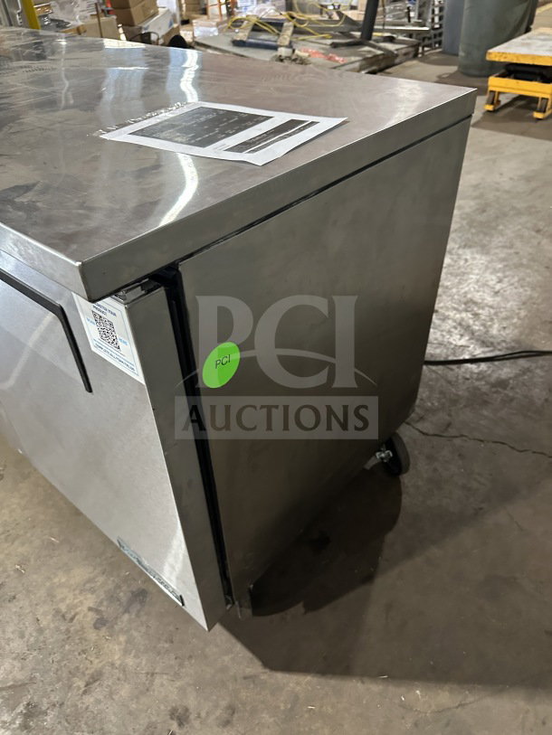 True TUC-72-HC stainless steel 3-door undercounter refrigerator, new condition, on casters, with poly coated wired rack.