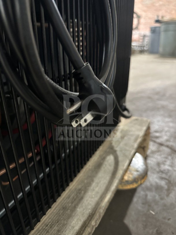 Close-up of a power cord and rear grill of a True CVM-24-HC-EGC01 commercial glass door merchandiser. New condition.