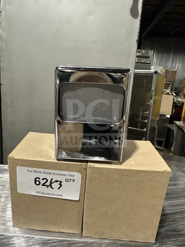 Brand new commercial chrome tabletop tallfold napkin dispenser, shiny finish, pictured atop cardboard boxes with a label.
