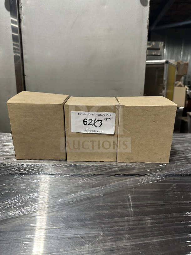 Brand new commercial chrome tabletop tallfold napkin dispenser boxed. Label reads "62K3 QTY" from PCIAuctions.com.