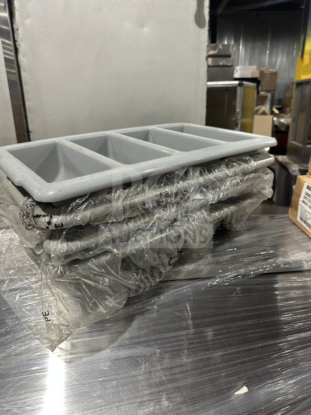 Brand new gray polyethylene 4-compartment flatware/cutlery box, wrapped in clear plastic. Durable kitchen essential.