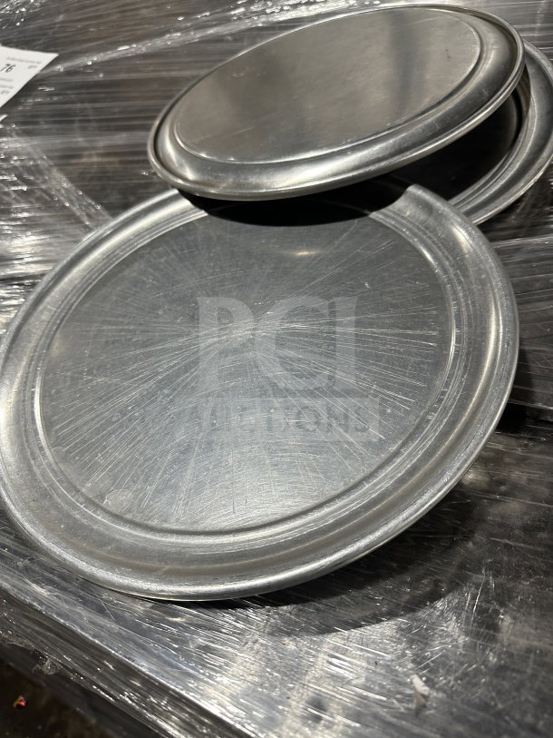 Commercial aluminum wide-rim pizza pans, new condition, with stack of trays. Scratches visible on surface, 7x auction bid.