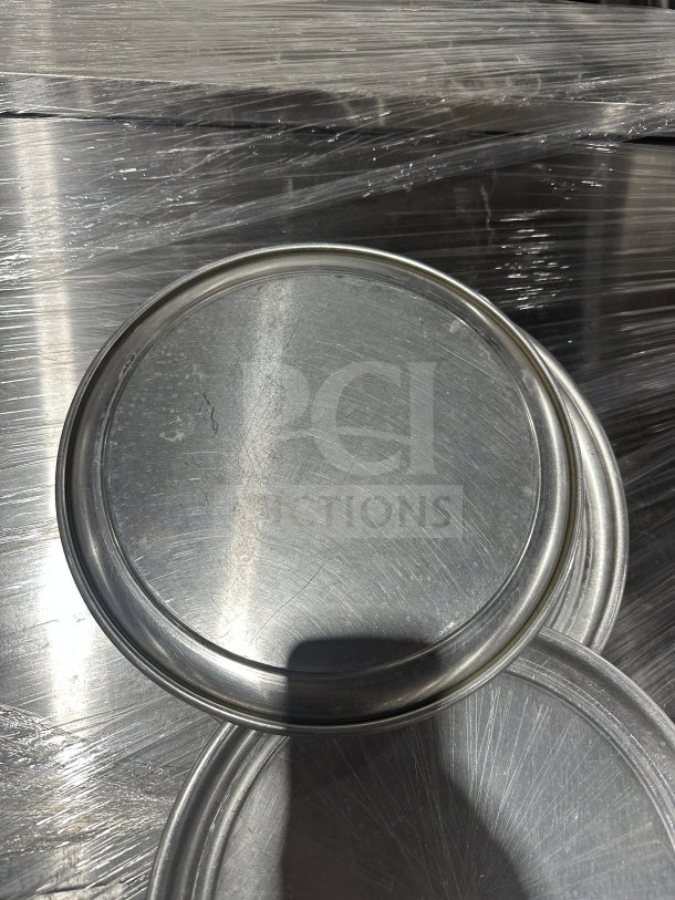 New commercial aluminum wide-rim pizza pans, multiple units. Durable construction, ideal for food service use.