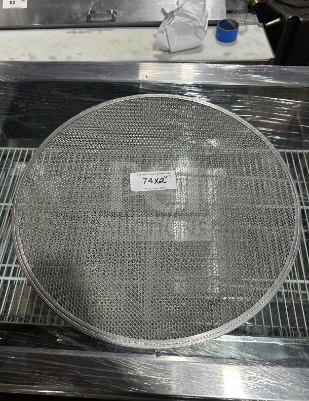 New commercial stainless steel pizza screen, mesh design, excellent condition, tag reads "74 X2 QTY".