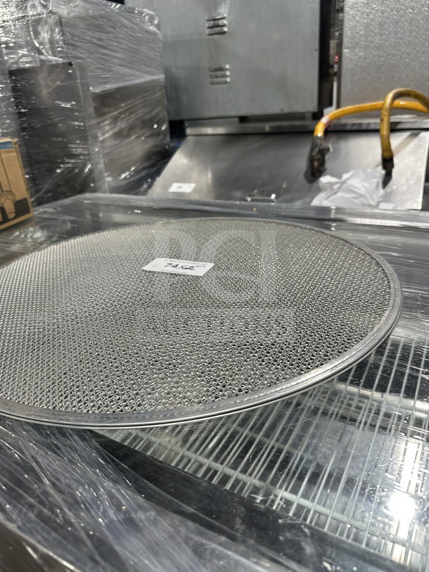 New commercial stainless steel pizza screen, mesh design, mint condition, with visible auction tag "74 x2".